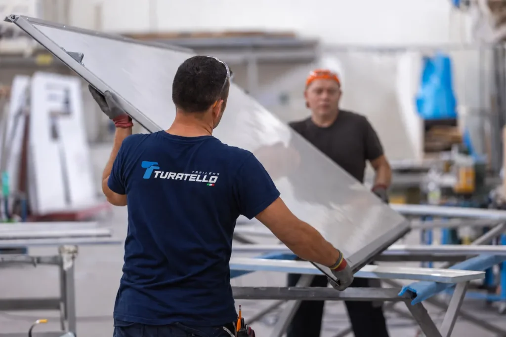 Operai Turatello Trailers al lavoro sull'assemblaggio di un pannello per rimorchio